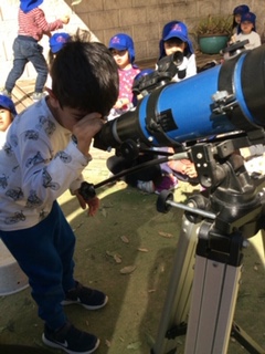 An image of kids using telescope in a childcare near me now.