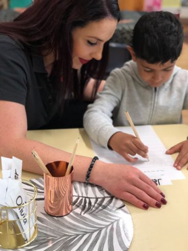 An image of a instructor assisting a child in learning centres.