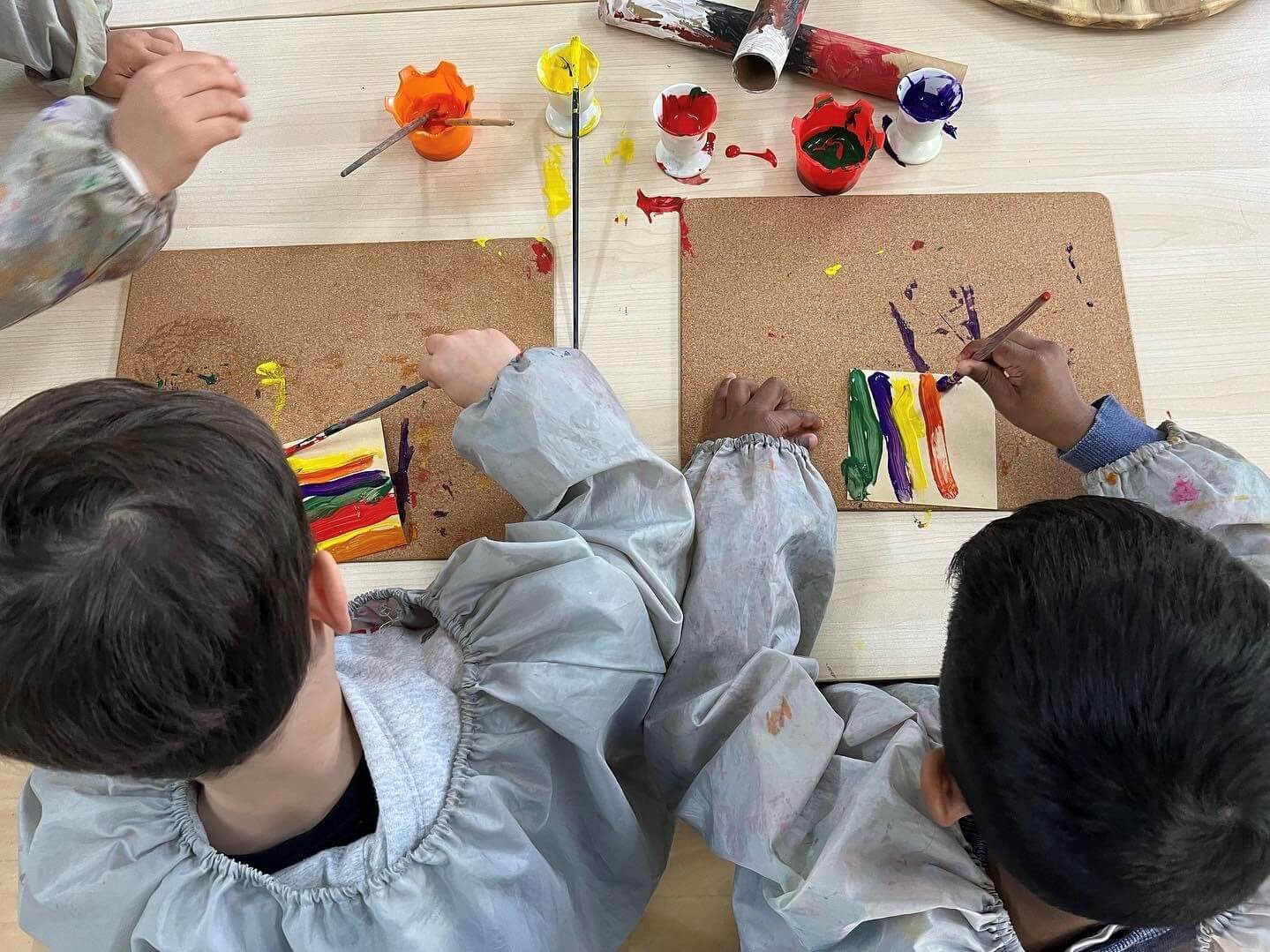 An image of children learning how to paint in childcare centres.