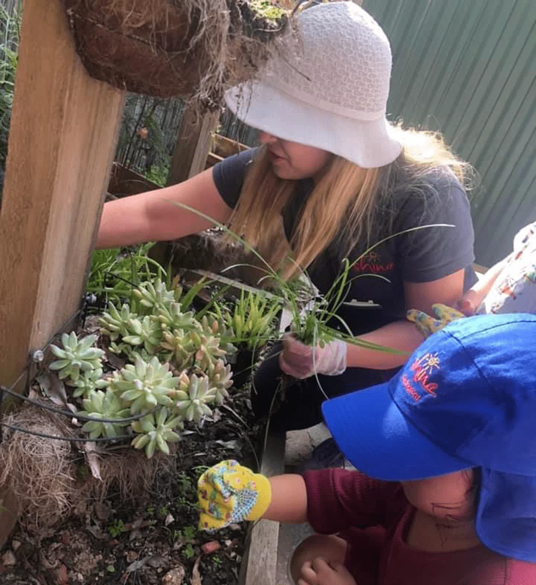 An image of two children playing together in a childcare centre with other educational leaders who are supervising them and mentoring them.