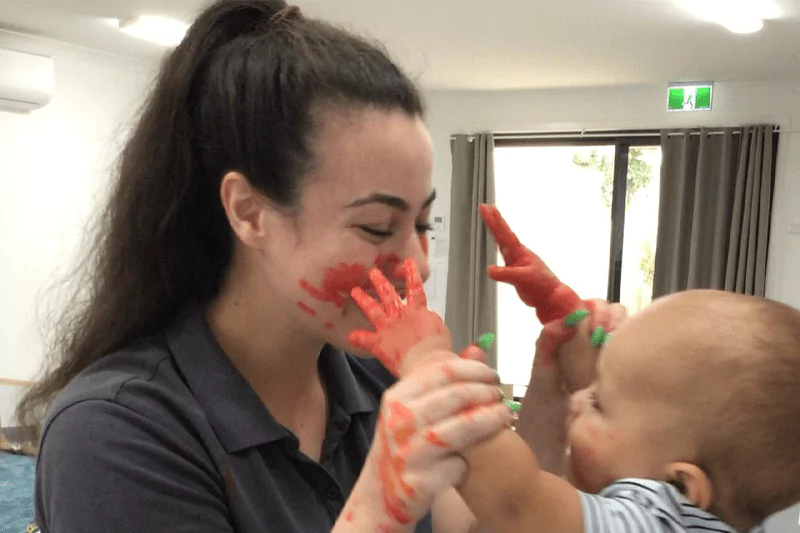 An image of a child with a teacher showing the role of educational leader in child development.